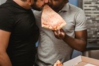 Man in Gray Crew Neck T-shirt Holding Sliced of Pizza