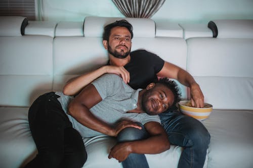 Free Men Resting on Sofa While Watching TV Stock Photo