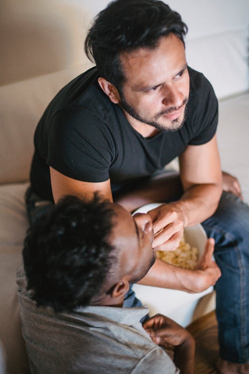 Free Photo of a Man Feeding a Man in a Gray Shirt Stock Photo