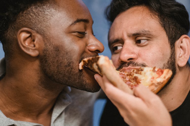 Photograph Of Men Eating Pizza Together