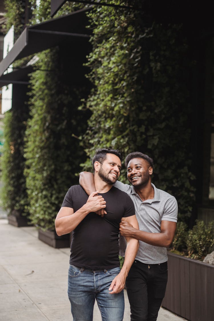 A Sweet Couple Walking On The Side Of The Street