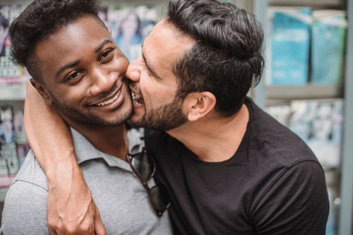 Free Happy LGBT couple sharing an intimate, playful moment together indoors. Stock Photo