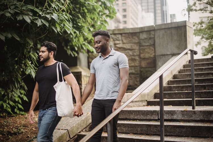 Photo Of Men Holding Hands While Going Down The Stairs