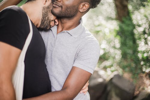 Free Photo of a Man in a Gray Shirt Hugging a Man in a Black Shirt Stock Photo