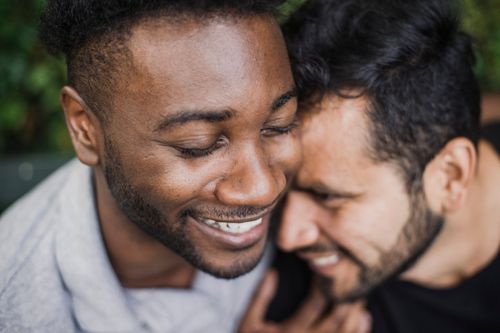 Free A close-up shot of a happy couple embracing and smiling warmly outdoors. Stock Photo