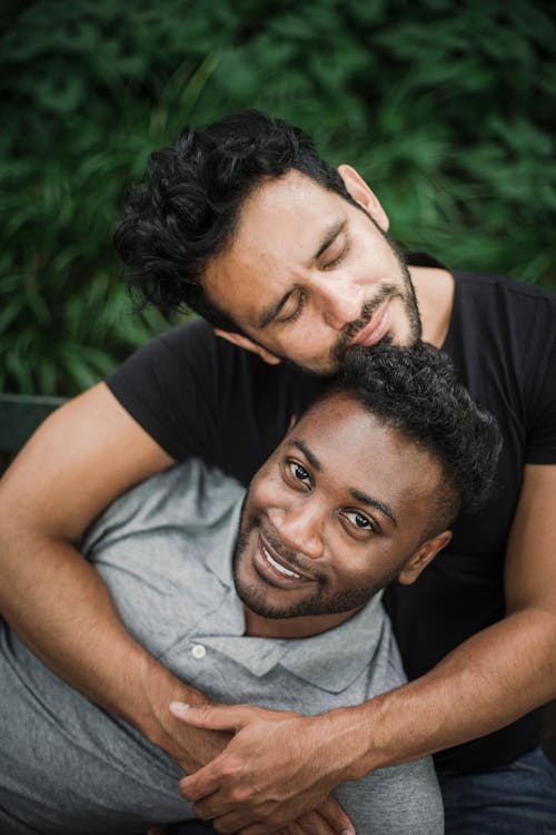 Free Photo of a Man in a Black Shirt Hugging Another Man Stock Photo