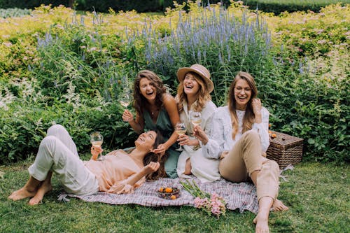 Women Sitting on Green Grass Field