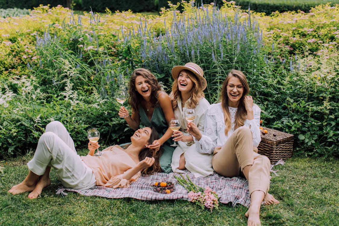 Free Women Sitting on Green Grass Field Stock Photo