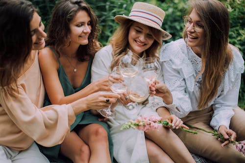 Free Friends Having a Toast while Sitting Next to Each Other Stock Photo