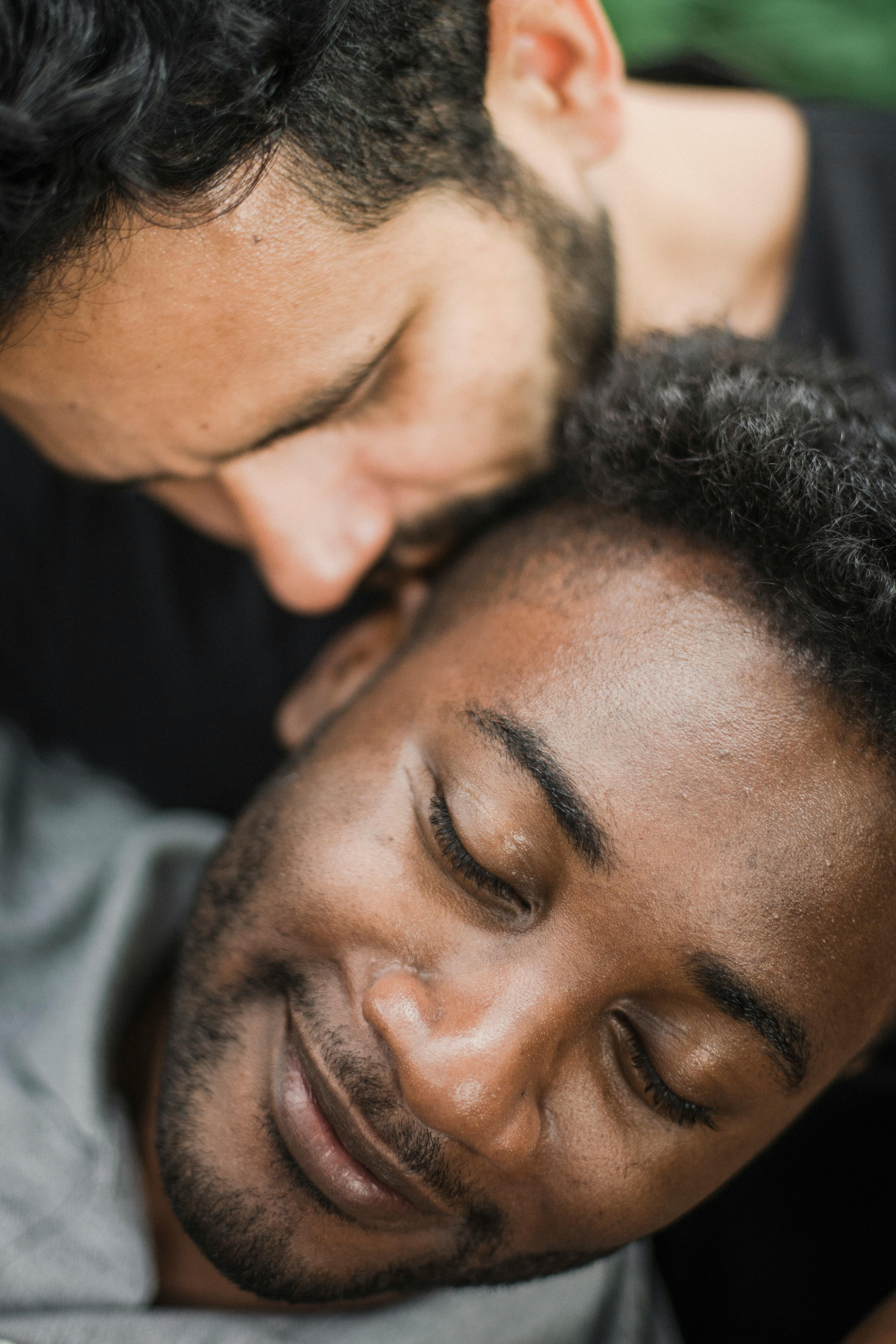 close up photo of a man kissing a man with his eyes closed