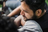 Man in Gray Shirt Lying on Black Textile