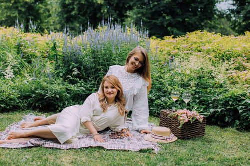 Free Two women enjoying a serene picnic in a vibrant garden setting. Perfect for lifestyle and leisure themes. Stock Photo
