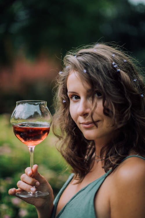 Free Curly Hair Woman Holding Glass of Wine  Stock Photo