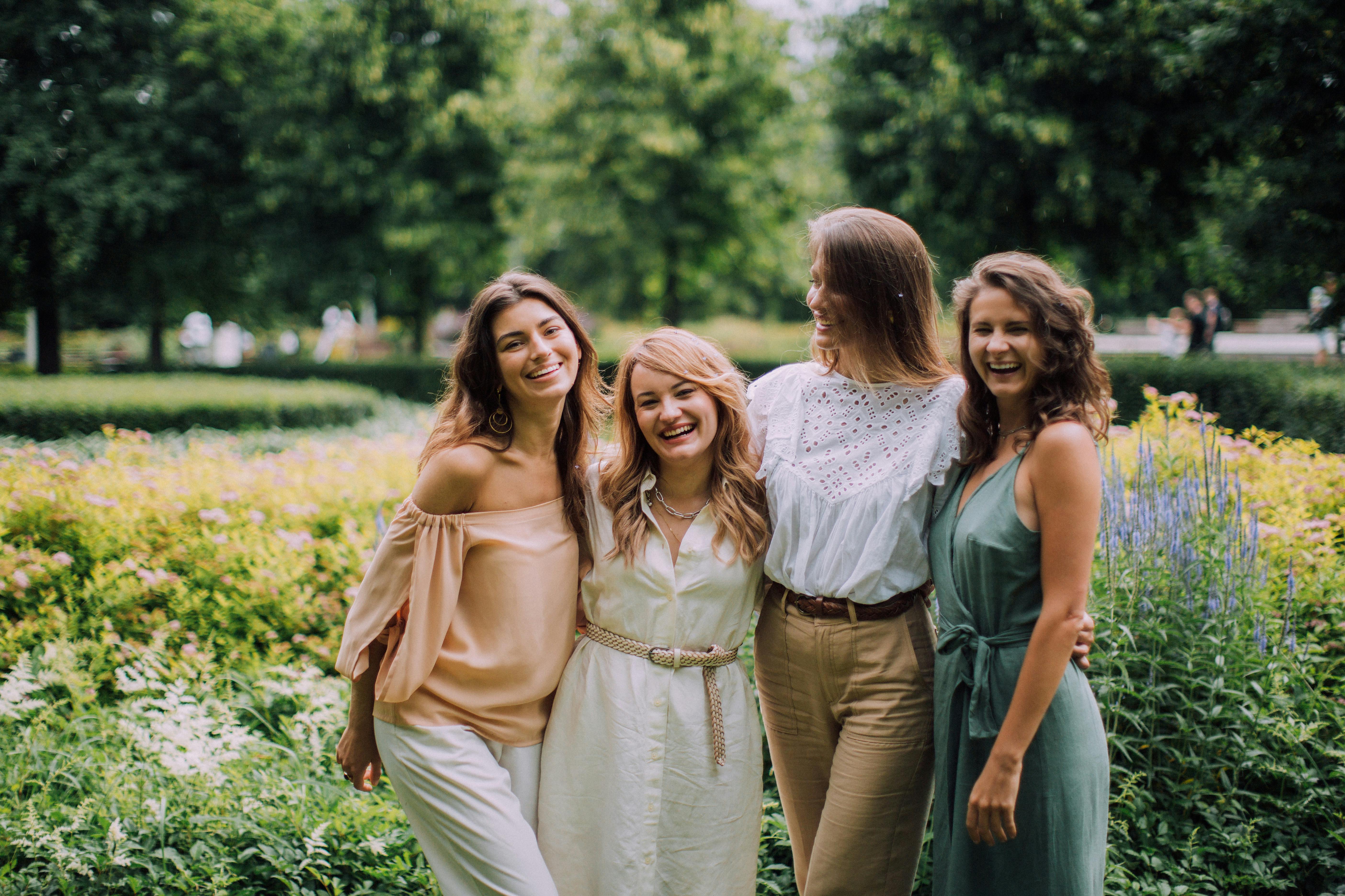 women standing beside garden plants