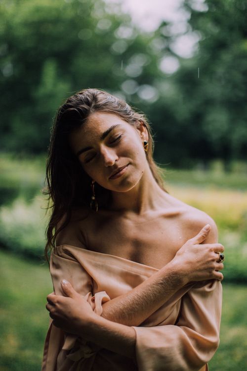 Free Gentle portrait of a woman with closed eyes embracing calm in natural park setting. Stock Photo