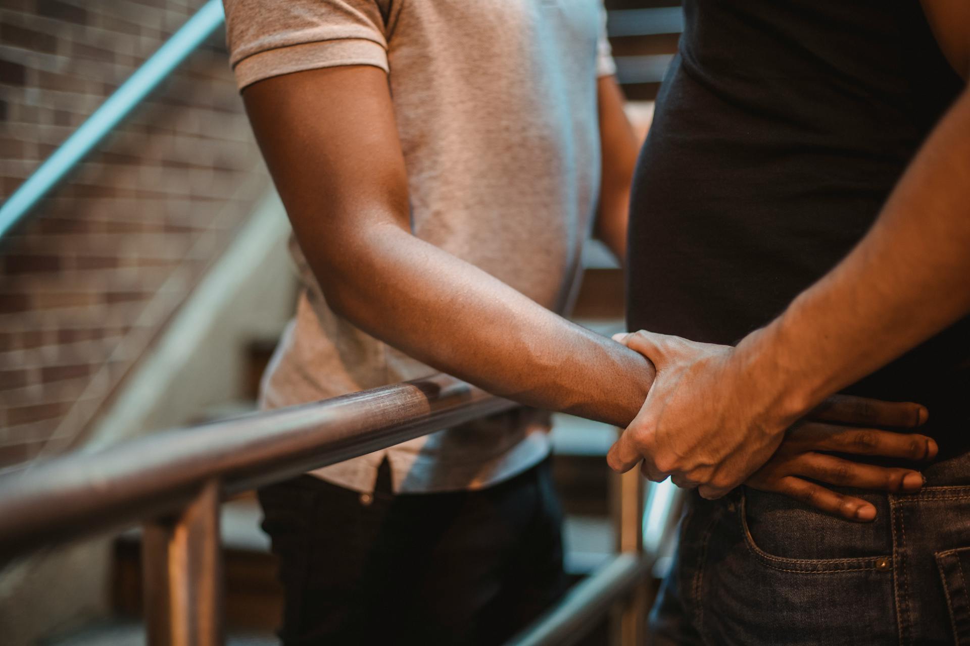 Close-up of a couple holding hands on a staircase, showcasing love and intimacy.