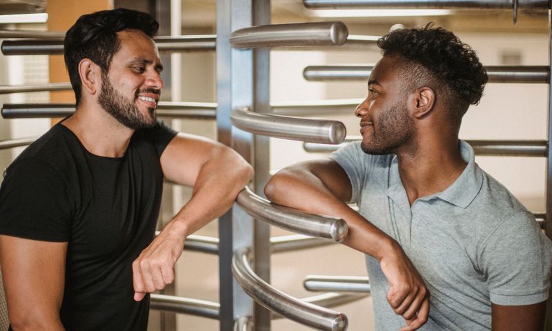 Dois alunos conversando ao lado de uma catraca torniquete