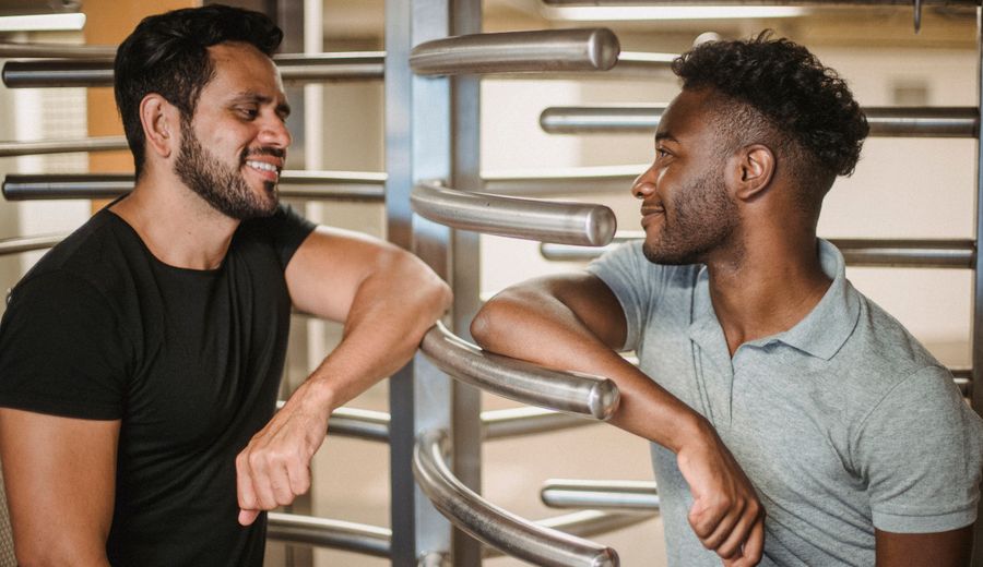 Dois alunos conversando ao lado de uma catraca torniquete