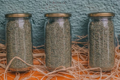 Close-up Photo of Glass Jars filled with Herbs 