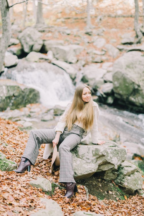 A Woman Posing on a Rock in the Woods