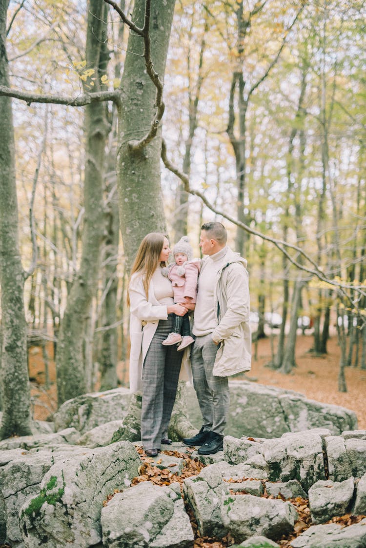  A Family Standing On A Rock In The Woods