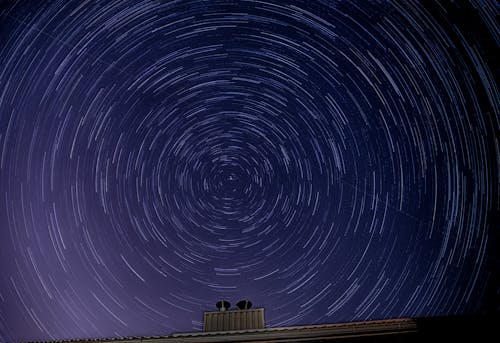 Stars in blue night sky over roof of building