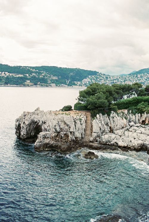 Free Aerial view of the French Riviera's rocky cliffs beside a calm ocean. Stock Photo