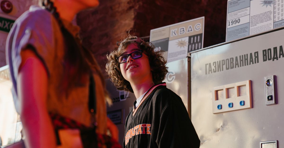 Teenagers enjoying a moment in front of retro vending machines, showcasing youth lifestyle indoors.