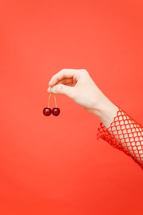 Close-up of a Hand Holding Cherries