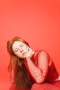 Woman in Red Fishnet Top with Hand on Chin