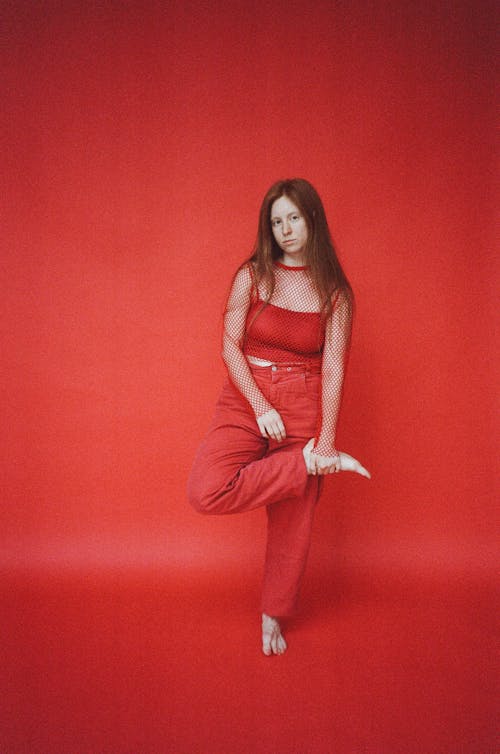 Barefooted Woman in Red Spaghetti Strap Top and Red Pants Standing on One Foot