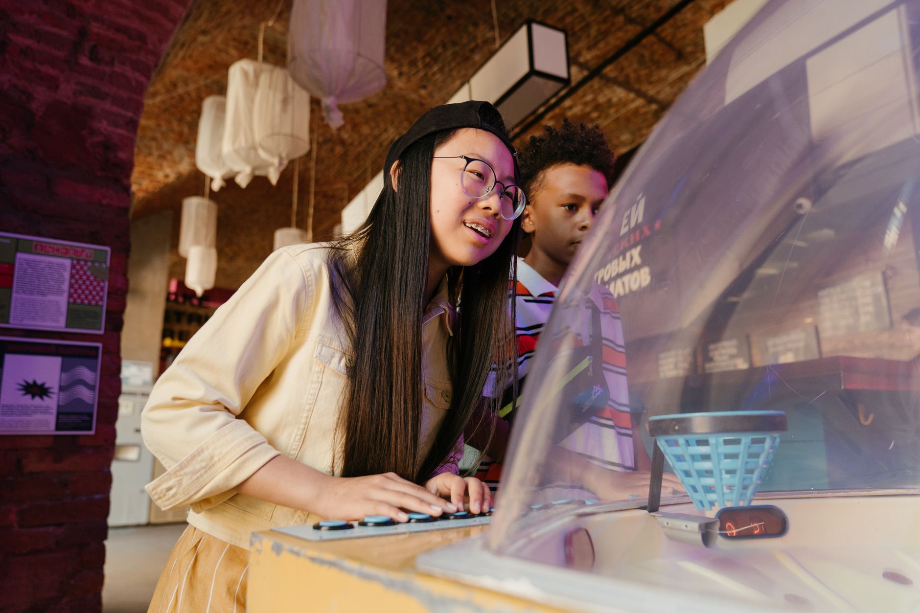 A group of teenagers having fun and playing arcade games indoors, capturing the essence of teen spirit.