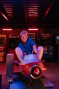 Woman in Blue Denim Jacket Riding Red Ride on Toy Car