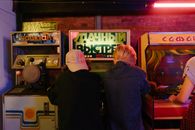 青少年们在复古街机里，玩着老式游戏机，享受乐趣