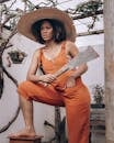 Young black woman with knife leaning foot on chair