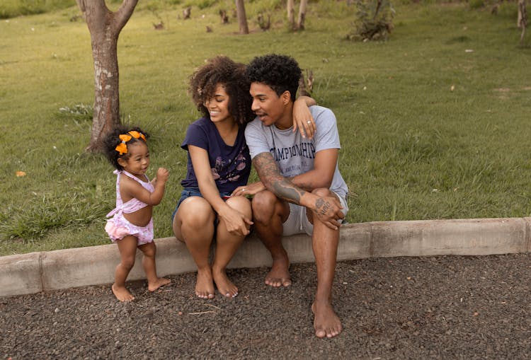 Happy Black Family Near Lawn With Green Grass