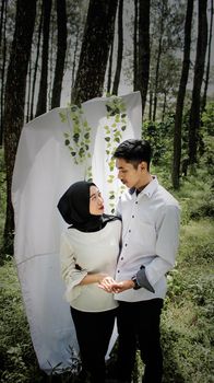 A romantic couple holding hands in a forest photoshoot in Bandung, Indonesia. - Fotografer Sidoarjo