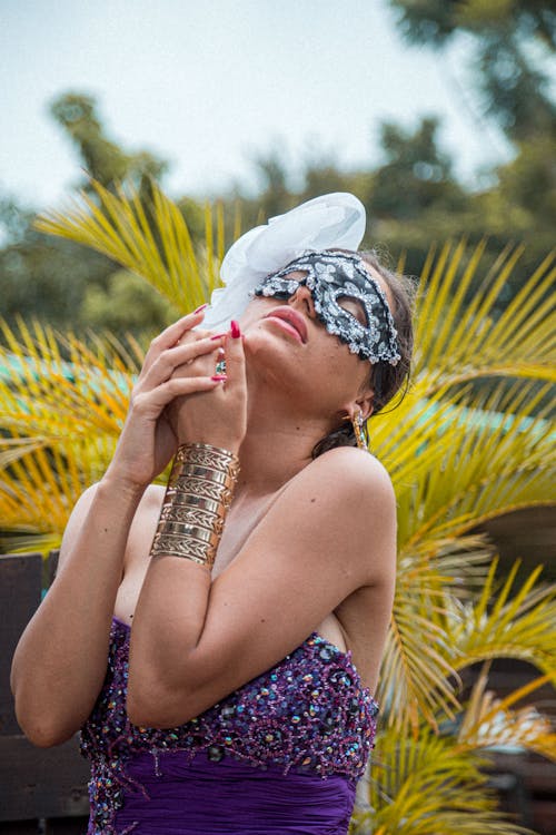 Stylish woman with mask near plants