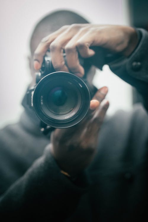 Close-Up Shot of a Person Holding a DSLR Camera