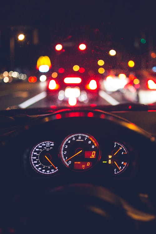 Modern car riding on city street at night