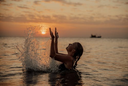 A Woman Swimming in the Sea during Sunset