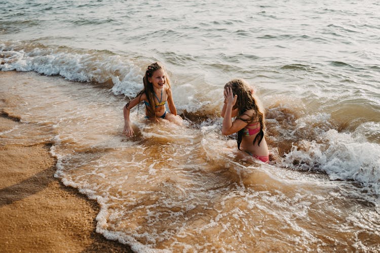 Two Happy Girls Swimming At The Beach