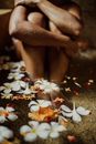 Person Sitting on Ground With White Flowers