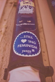 A vertical shot of a pipe with stickers, including a feminism slogan.