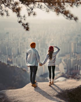 一对夫妇手牵着手，从悬崖上俯瞰首尔的城市天际线
