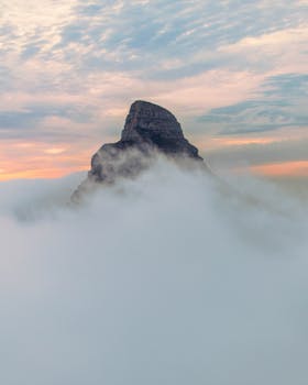 A stunning view of Lion's Head surrounded by mist and clouds during sunrise in Cape Town, South Africa.
