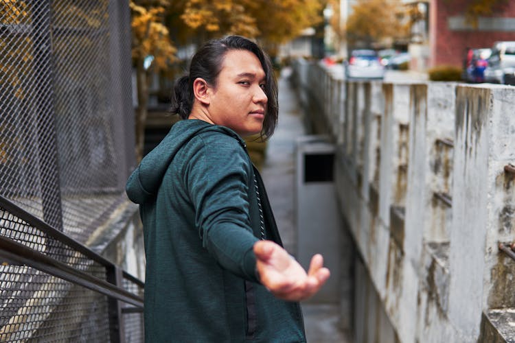 Man Walking Looking Over Shoulder And Reaching His Hand 