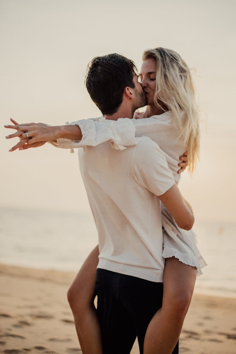 A Couple Kissing On The Beach