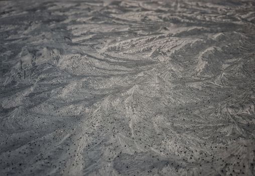 Detailed close-up of frost patterns creating an abstract design on a window surface.