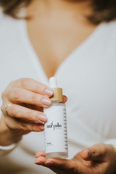 Close-up view of hands holding a misolo skin care serum bottle, showcasing its design and appeal.
